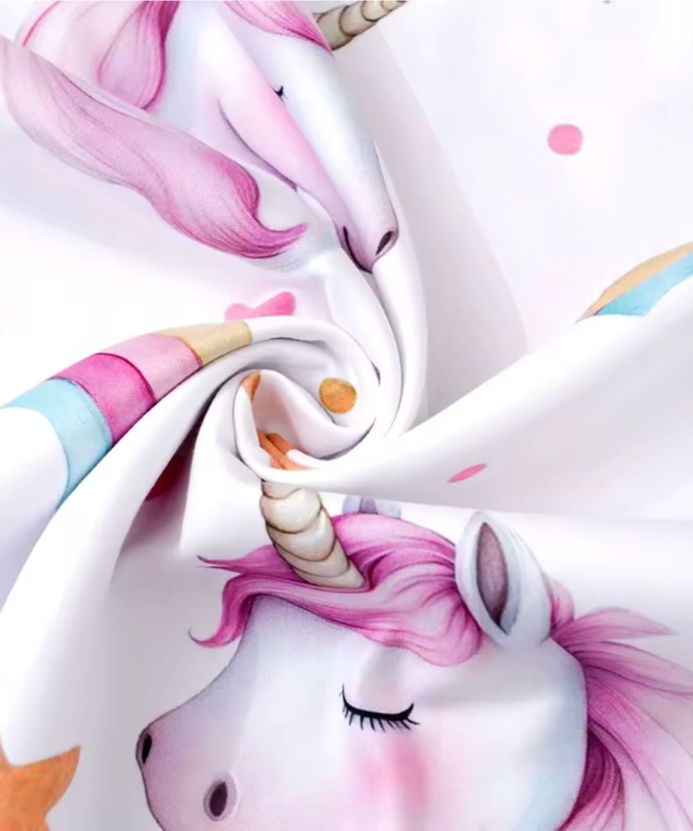 Détail du tissu doux d'un poncho serviette bébé Planète Poncho avec motif licorne rose