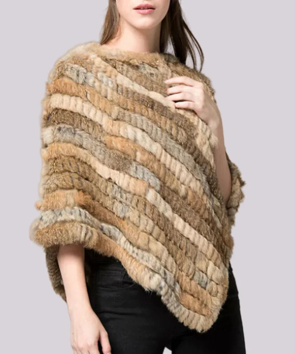 Femme portant un poncho beige avec fausse fourrure, style élégant et hivernal.