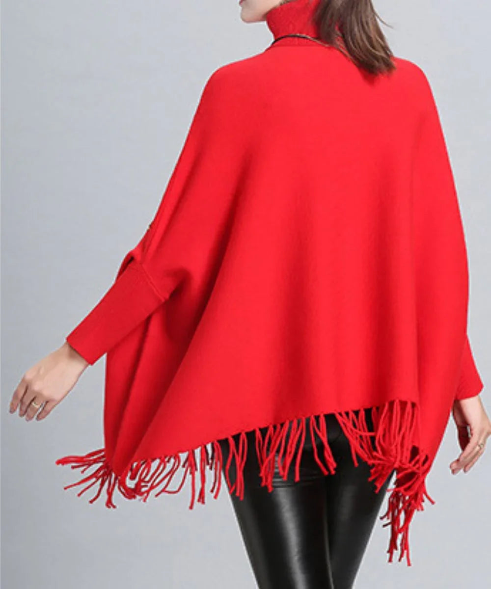 Poncho rouge à col roulé en cachemire, franges, porté avec un pantalon noir