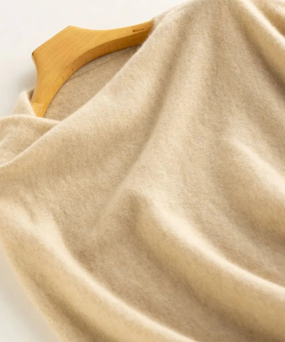 Poncho court en cachemire beige sur cintre, texture douce et élégante
