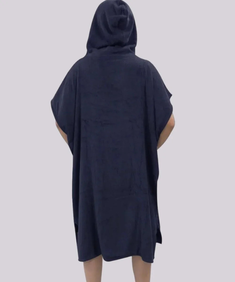 Homme de dos portant un poncho de bain surf bleu marine à capuche, fond uni
