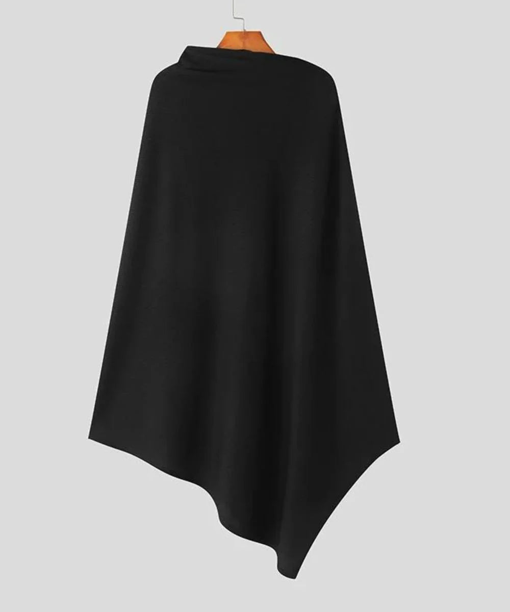 Poncho homme noir élégant, coupe asymétrique, suspendu sur un cintre, fond gris.