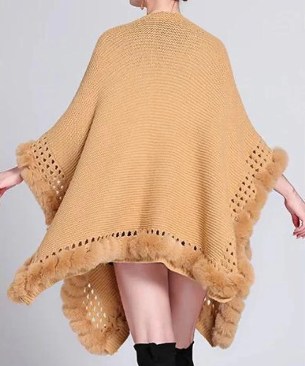 Poncho grande taille beige en maille avec bordure en fausse fourrure, porté par une femme