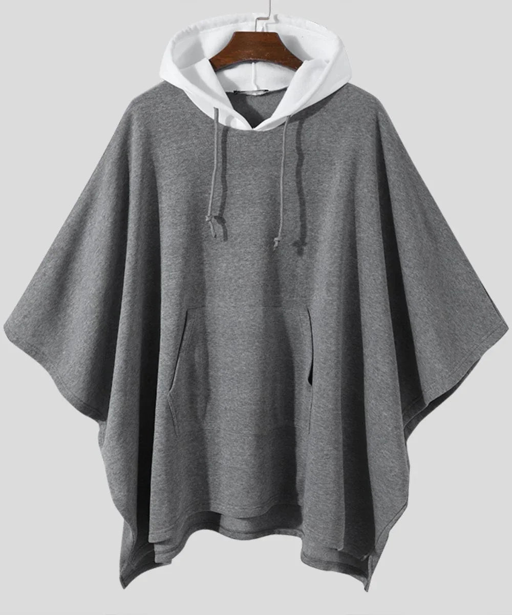 Poncho pilou pilou homme gris à capuche blanche, manches larges, poche frontale.