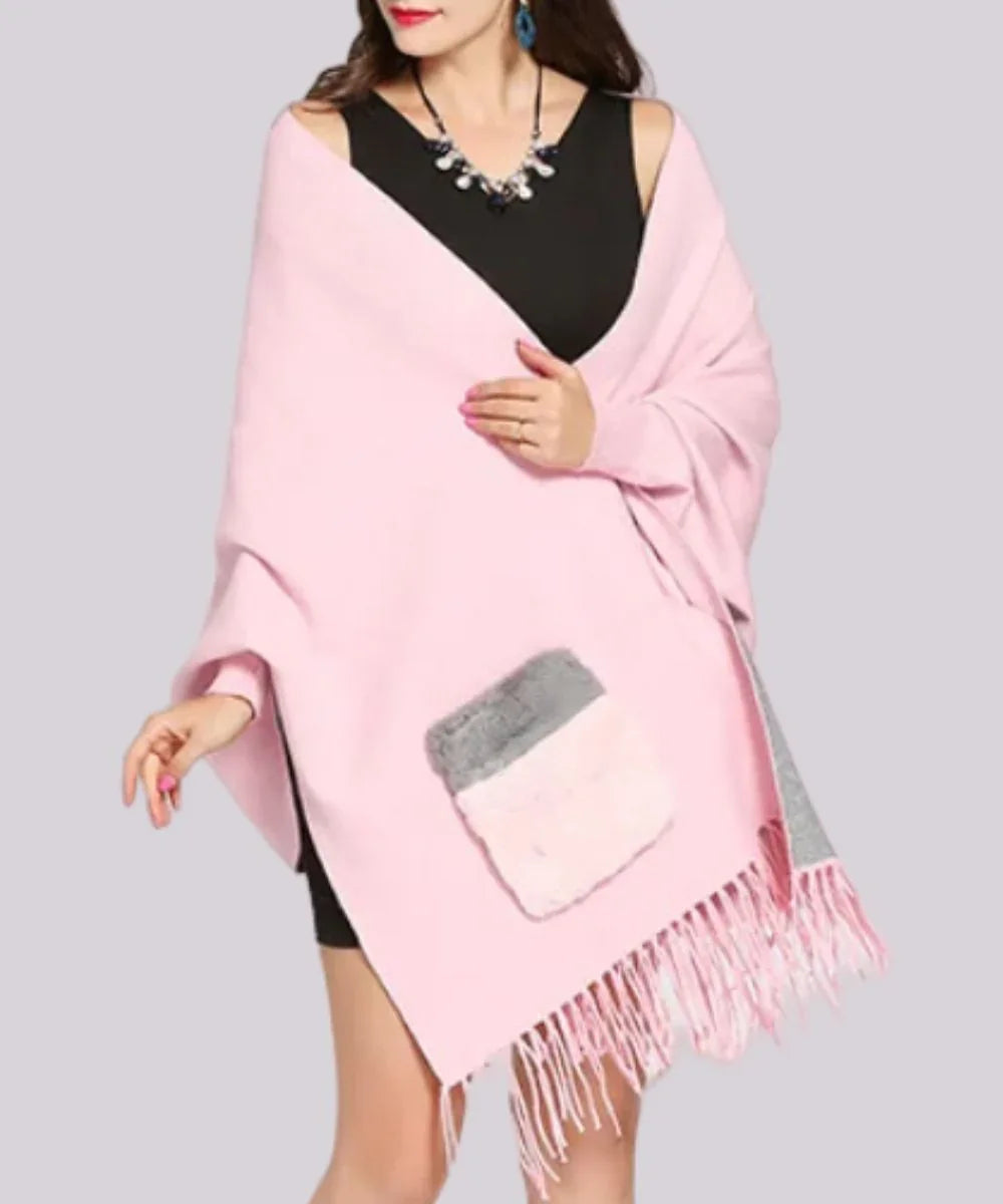 Poncho rose pâle pour femme avec franges et poche contrastée, porté sur robe noire