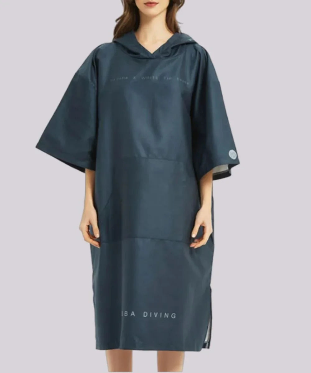 Femme portant un poncho de surf imperméable bleu marine avec capuche et manches courtes.