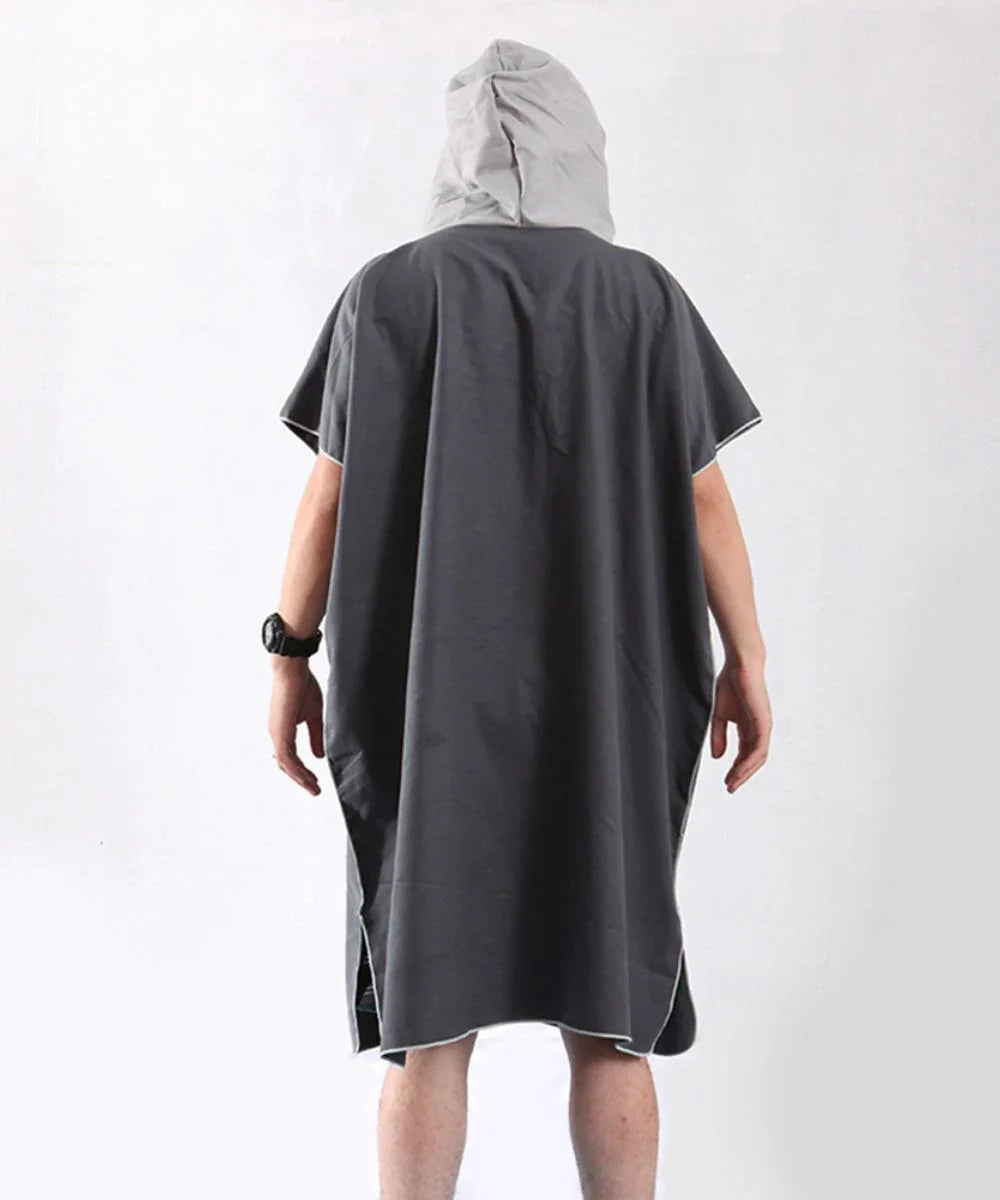 Homme vu de dos portant un poncho de bain gris à capuche, sur fond blanc, style décontracté