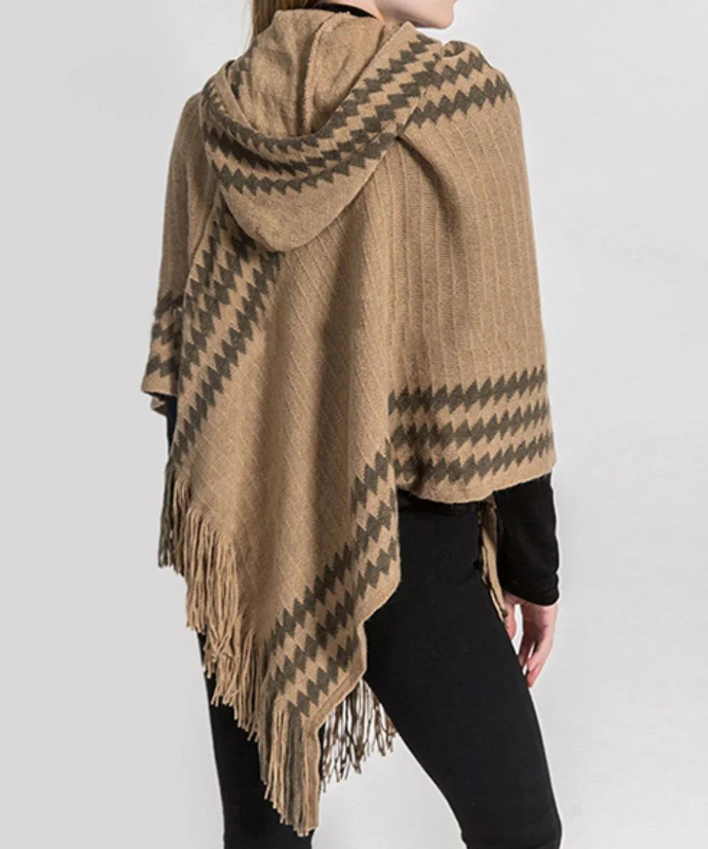 Poncho femme beige à capuche, motif géométrique, franges, porté sur un pantalon noir