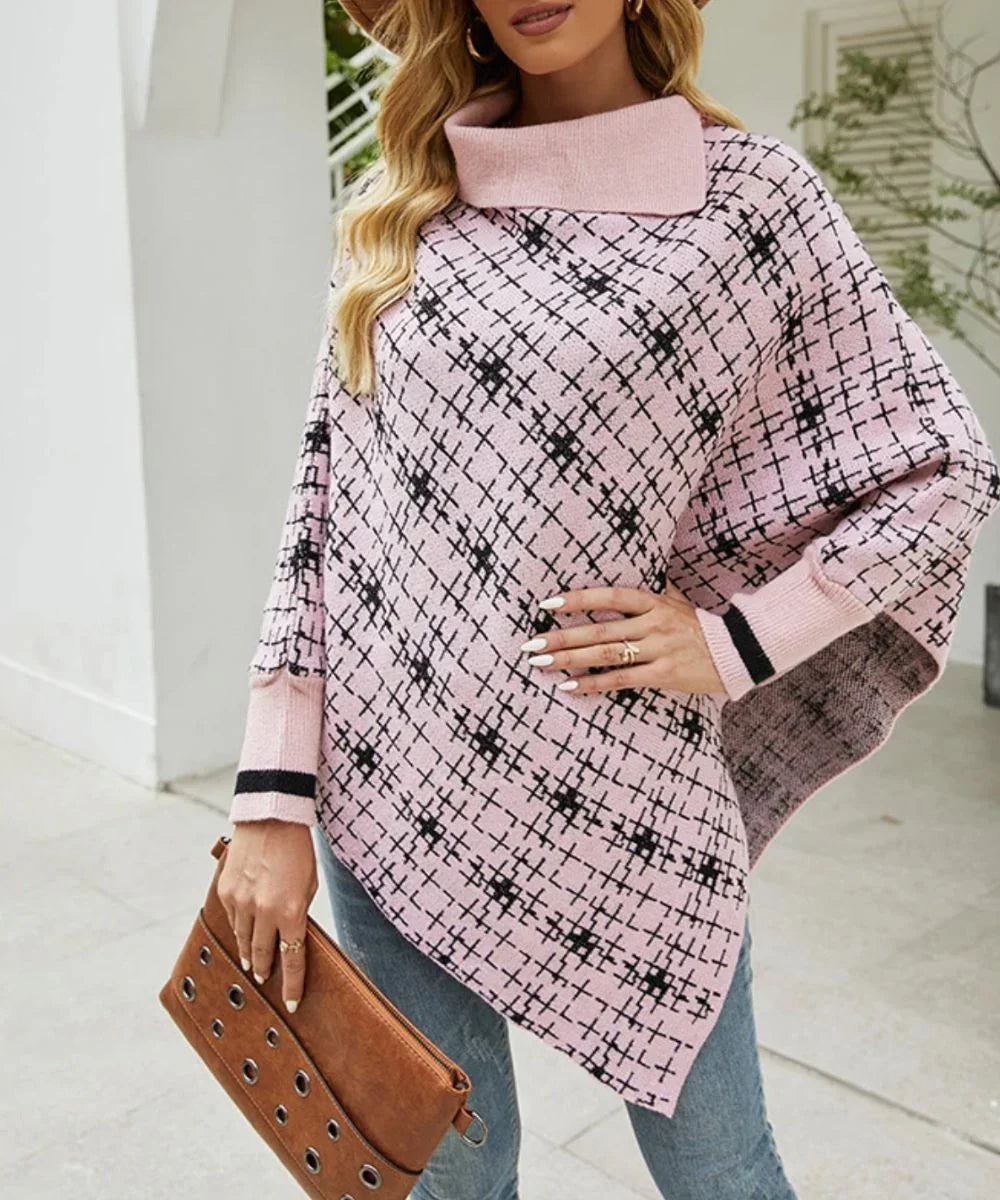 Poncho femme rose pâle à motif géométrique noir, col roulé, porté avec un sac marron