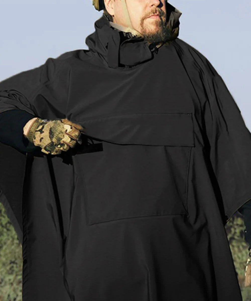 Homme portant un poncho noir à capuche avec grande poche avant en extérieur