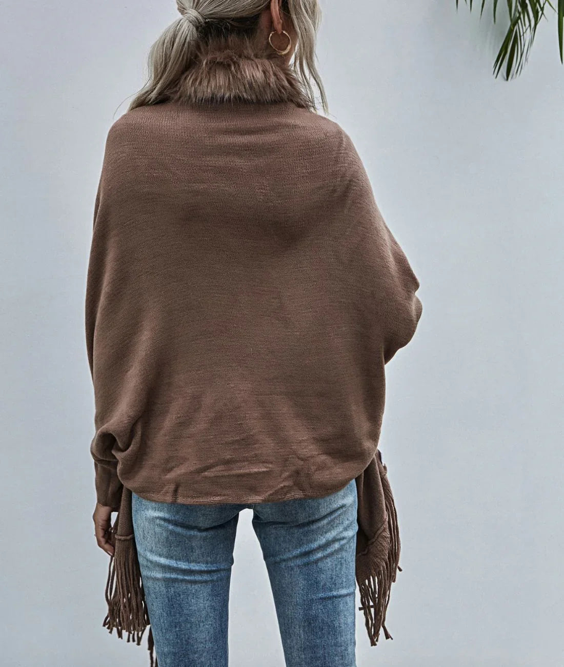 Femme portant un poncho marron à col en fausse fourrure et franges, vue de dos