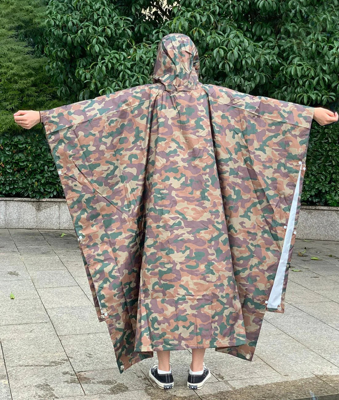 Poncho de pluie camouflage kaki avec capuche, porté dehors, idéal pour l'extérieur
