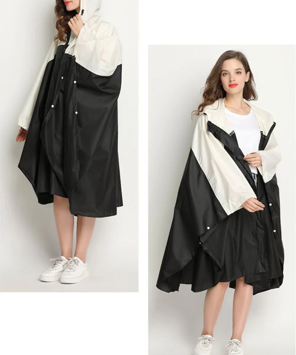 Femme portant un poncho de pluie noir et blanc avec capuche, manches longues, style décontracté.
