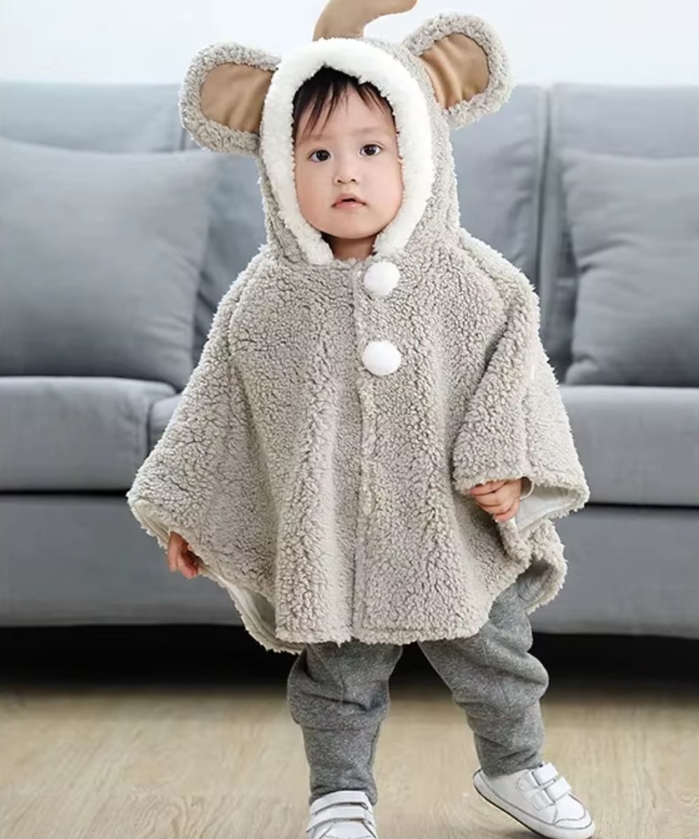 Bébé portant un poncho en polaire beige Planète Poncho avec capuche à oreilles d'ours.