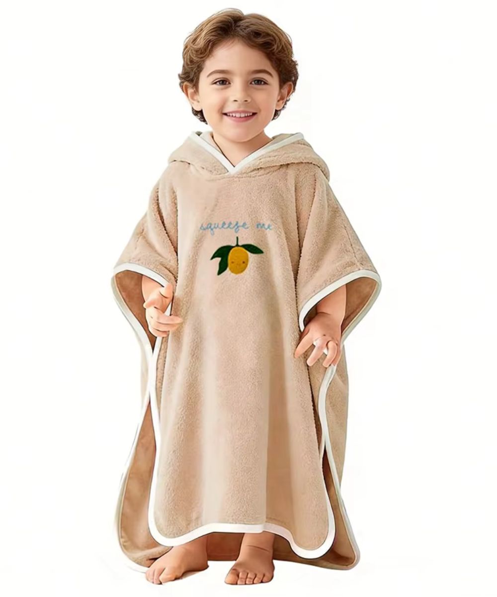 Bébé portant un poncho de plage beige à capuche avec motif citron de planète poncho