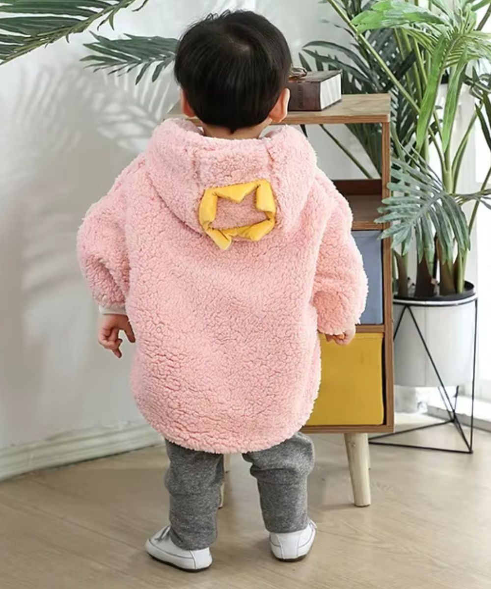 Bébé de dos portant un poncho rose en polaire avec capuche Planète Poncho.