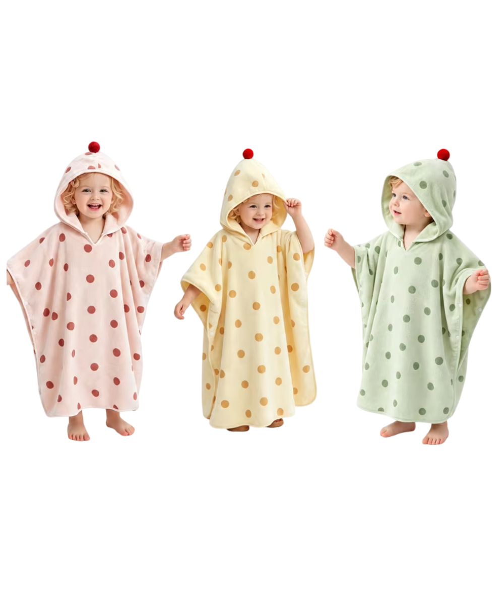 Trois bébés portant des ponchos de bain à pois Planète Poncho en rose, jaune et vert.
