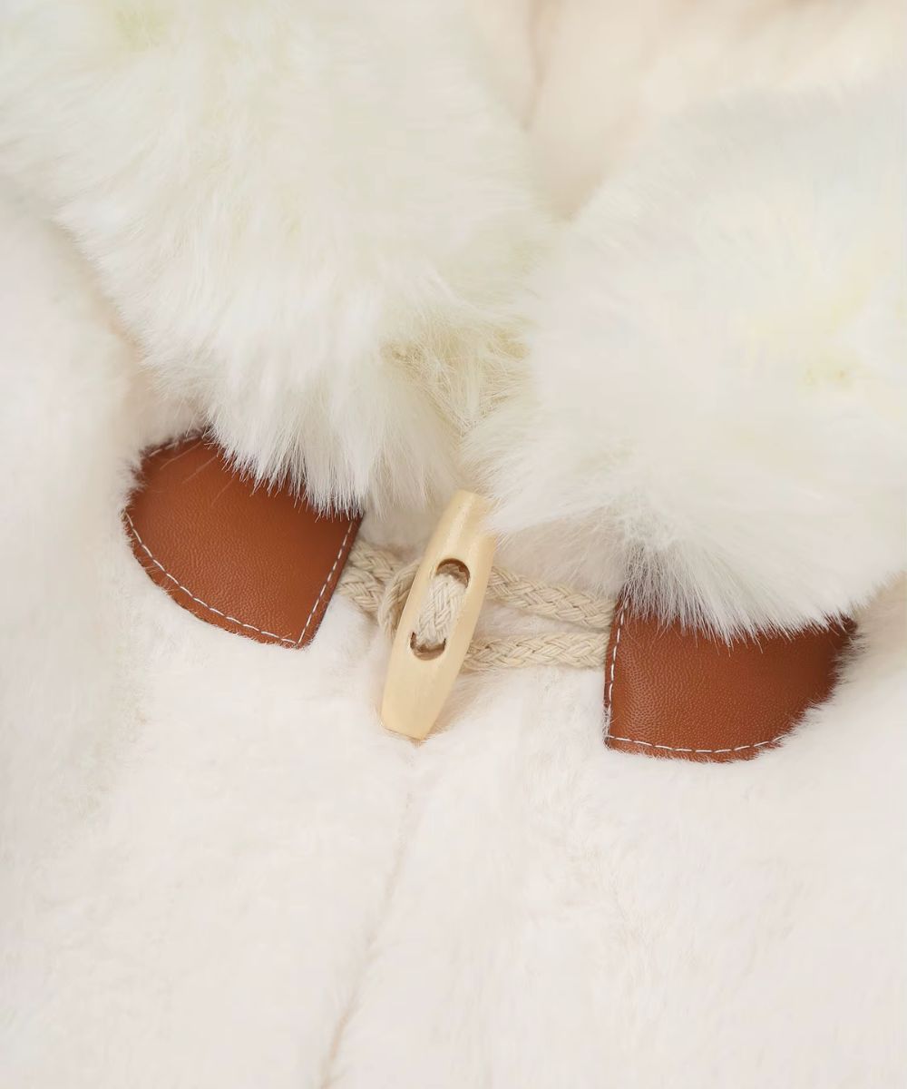 Détail du bouton en bois et fermeture en cuir d'un poncho bébé en fausse fourrure blanche Planète Poncho