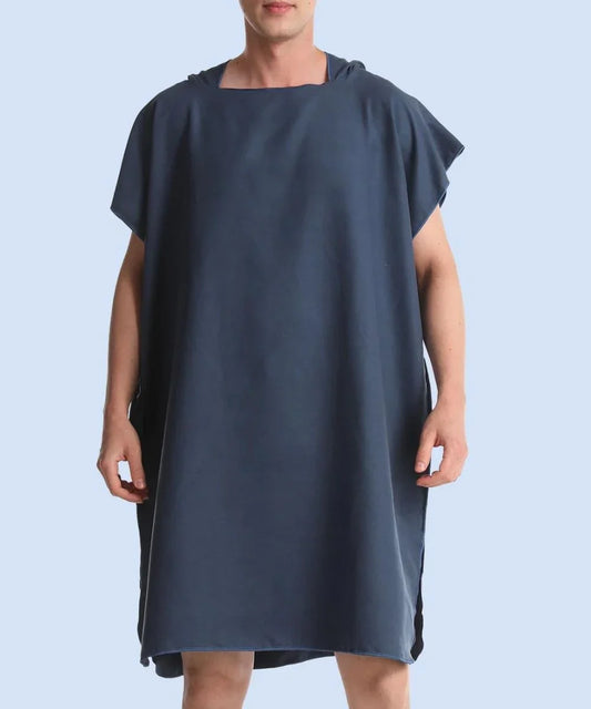 Homme portant un poncho serviette surf bleu, coupe ample, fond uni clair